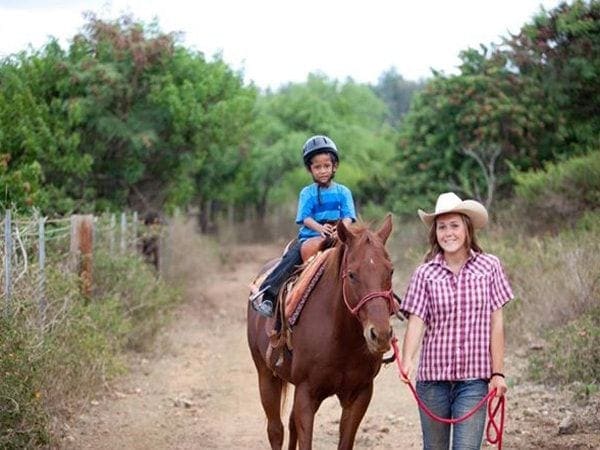 A woman and child riding on the back of a horse.