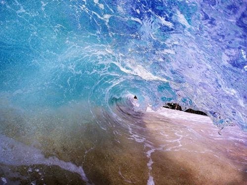 A surfer is riding the waves on his surfboard.