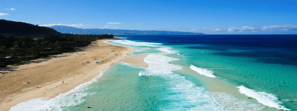 A beach with people swimming in the water.