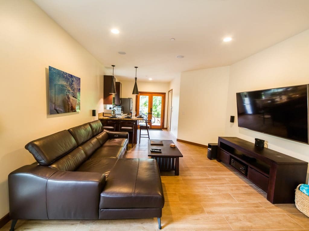 A living room with brown leather furniture and a flat screen tv.