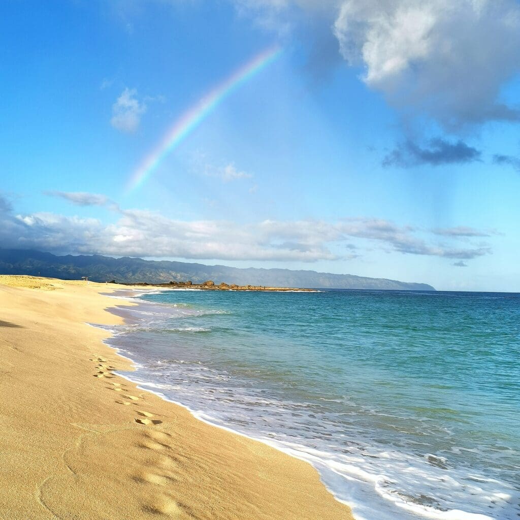 A rainbow over the ocean and beach.