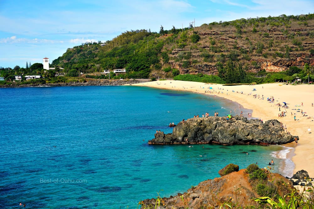 A beach with people swimming in the water.